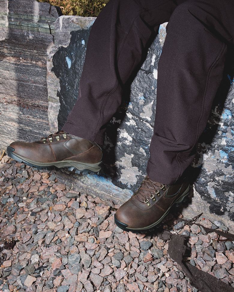 a pair of feet wearing waterproof brown boots