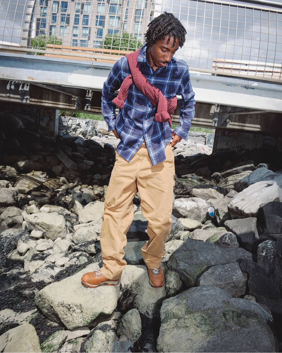 man standing on wet rocks in waterproof boots