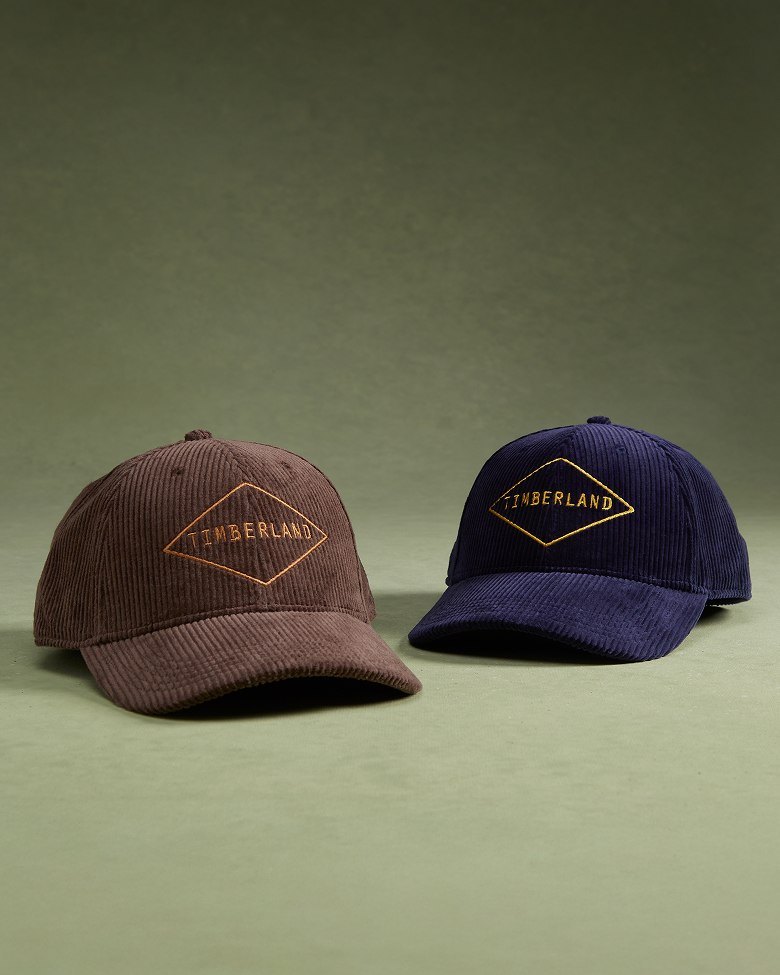 a brown snapback with the timberland logo next to a blue snapback with the timberland logo