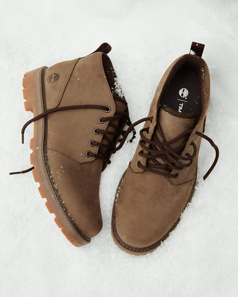 a pair of feet wearing black shoes and jeans