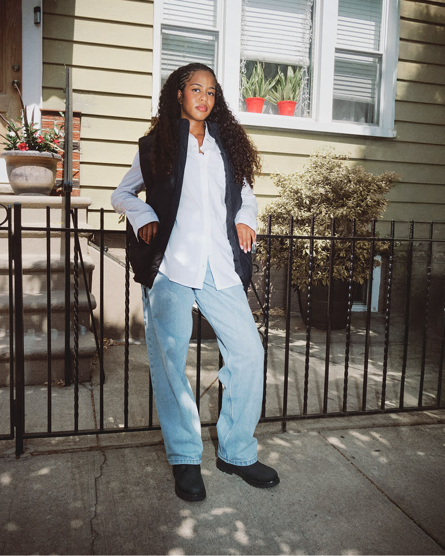 woman wearing jeans with black boots with white button up shirt