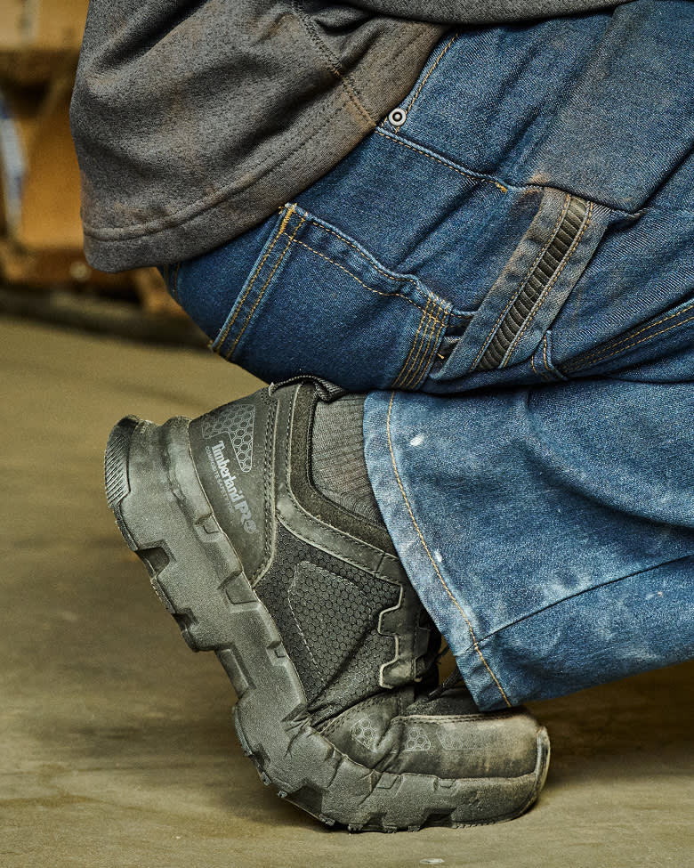 worker bending down in black work boots and jeans