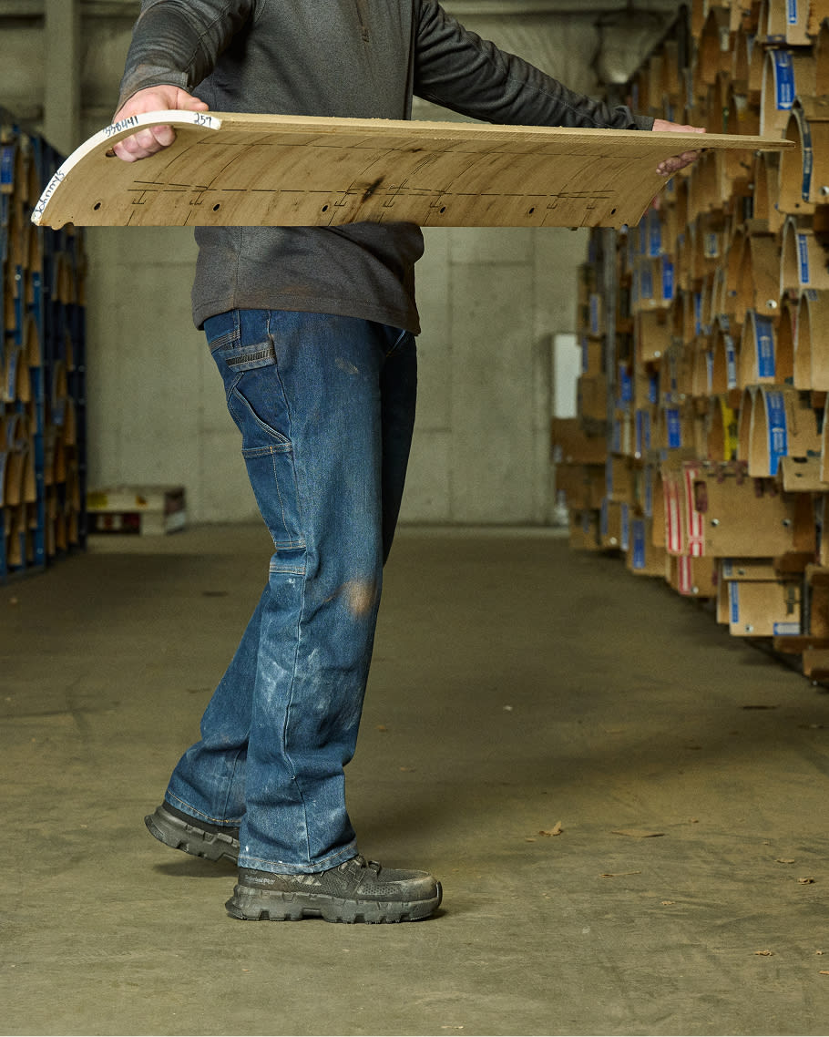 worker carrying a piece of wood in timberland work boots