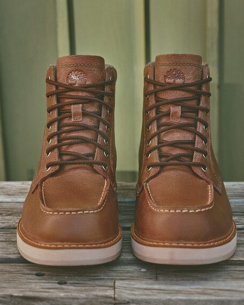 a pair of brown leather boots with the timberland logo standing upright