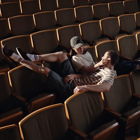 A man and a woman sitting in chairs in an auditorium