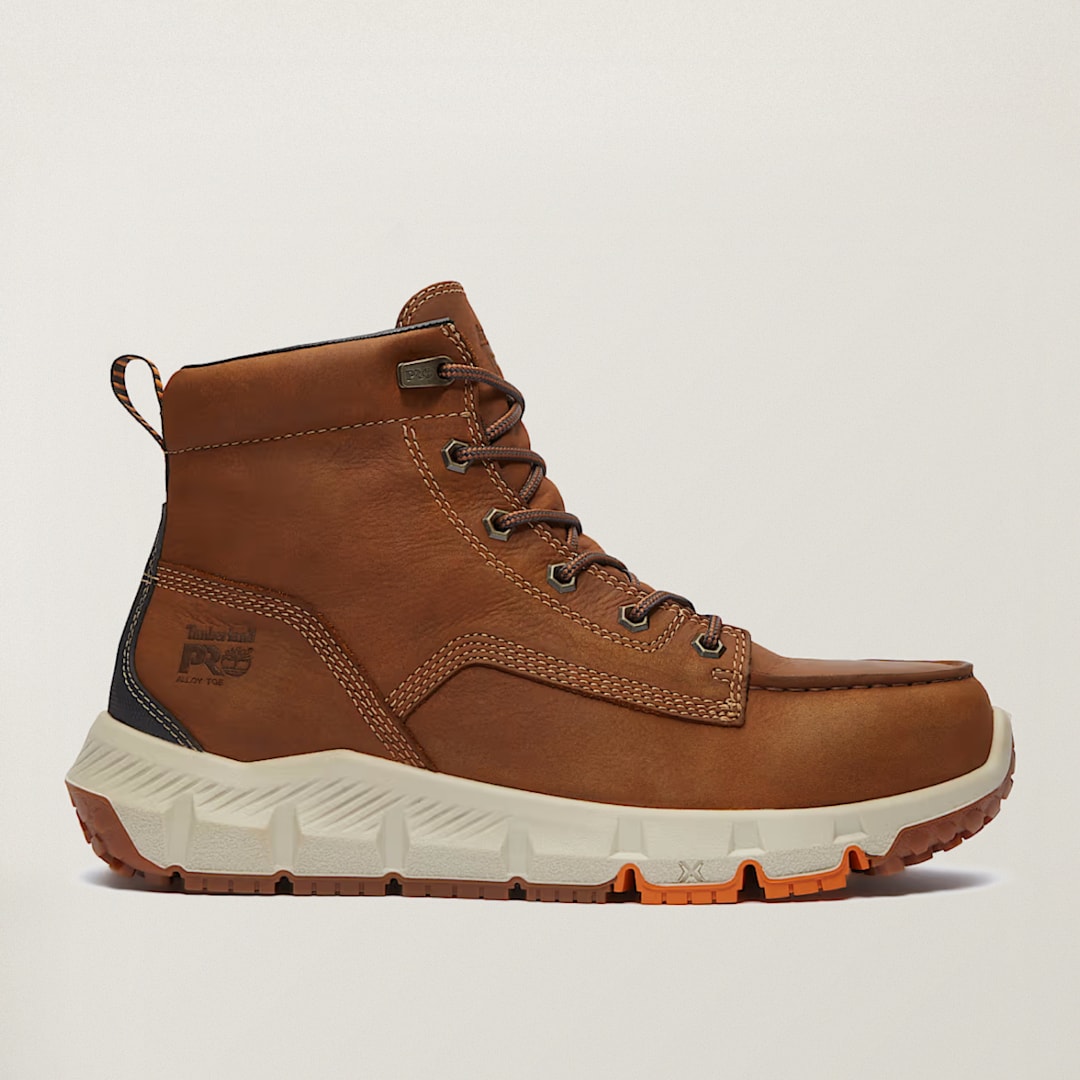 Timberland PRO work boot in brown leather with a moc-toe design, dark brown laces, and a white-and-orange outsole, shown in side profile.