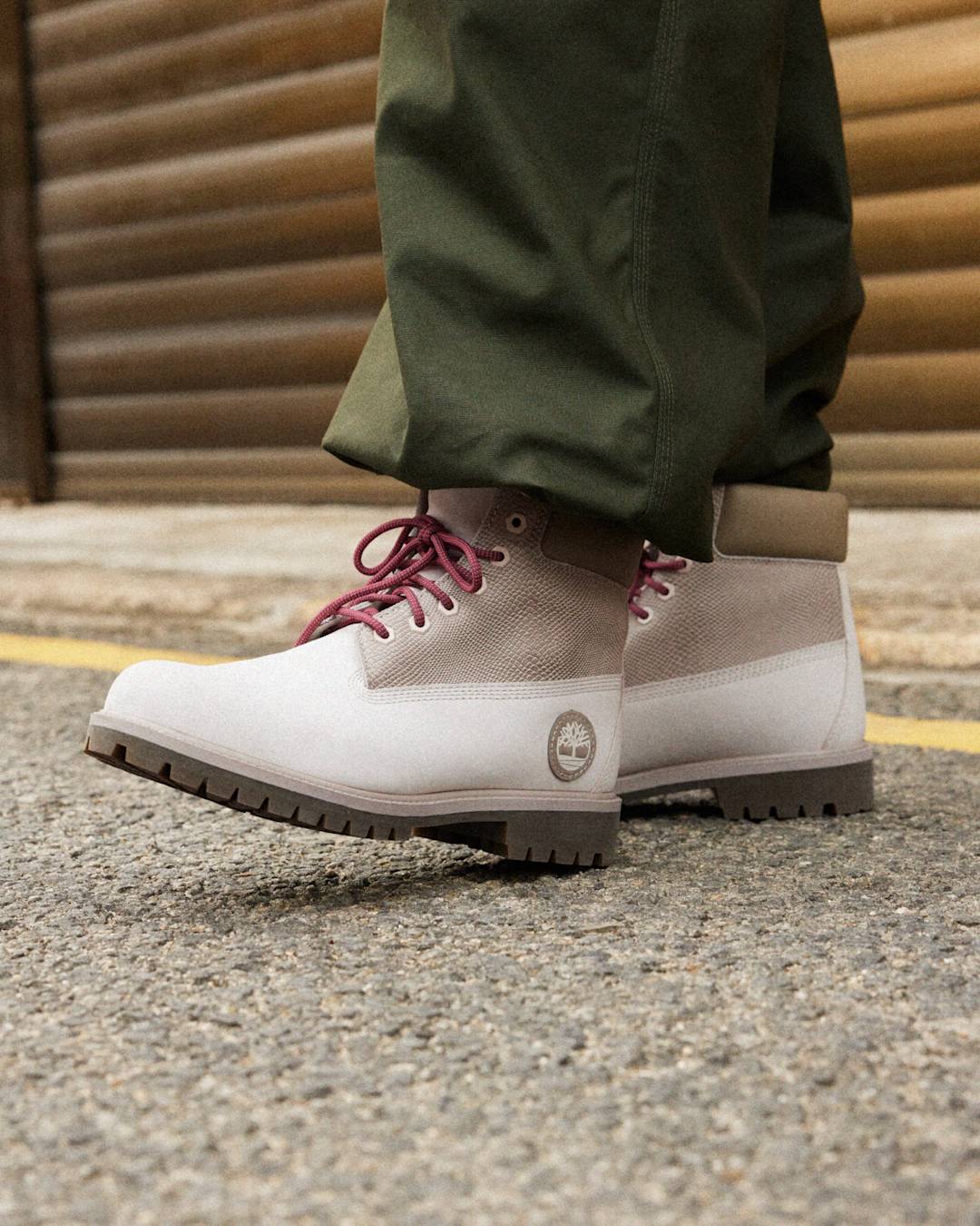 A two toned grey boot with red laces. 