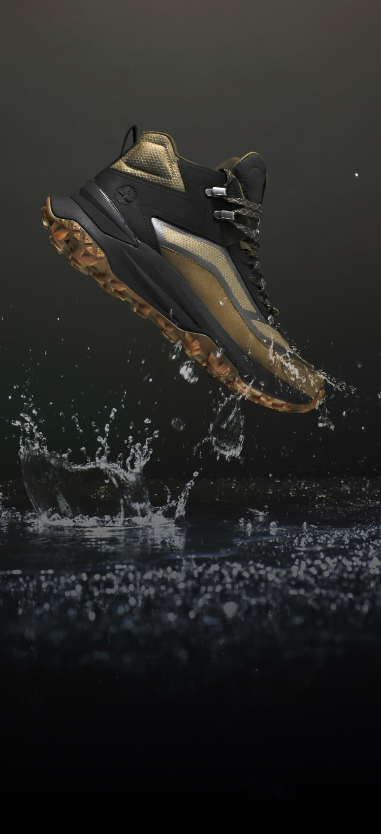A hiking boot on a dark backdrop rising out of water. 