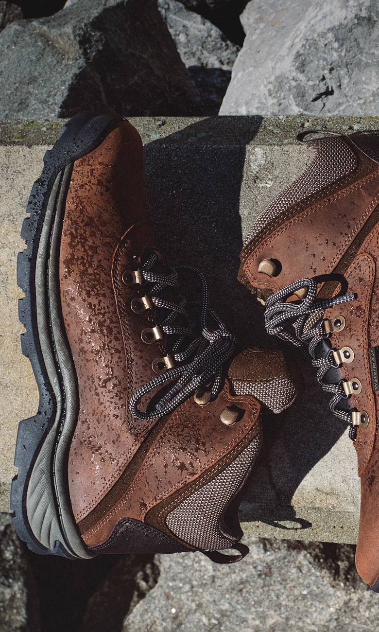 a pair of brown boots covered in water droplets