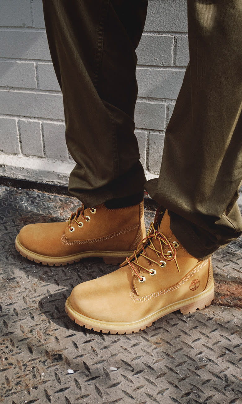 a pair of feet wearing brown boots and green pants