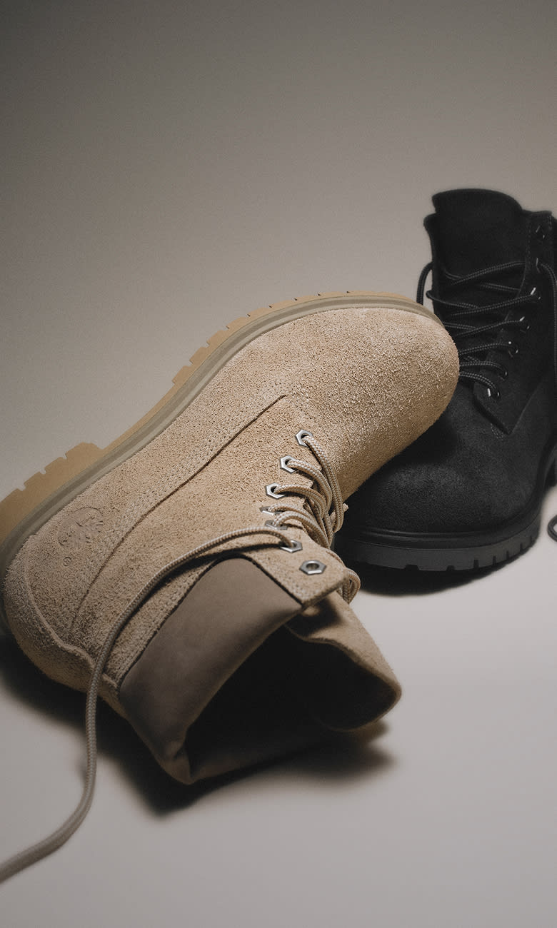 one gray suede boot leaning on one black suede boot
