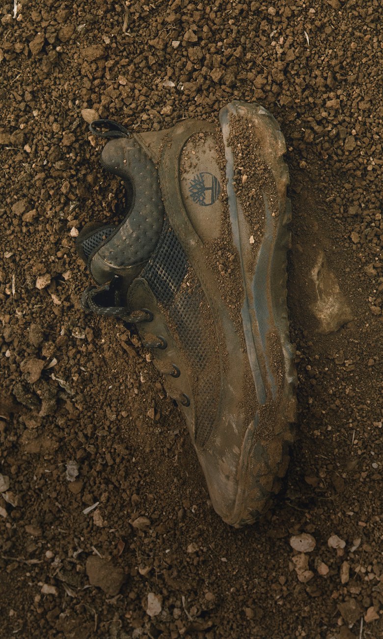 black timberland shoe covered in dirt on soil