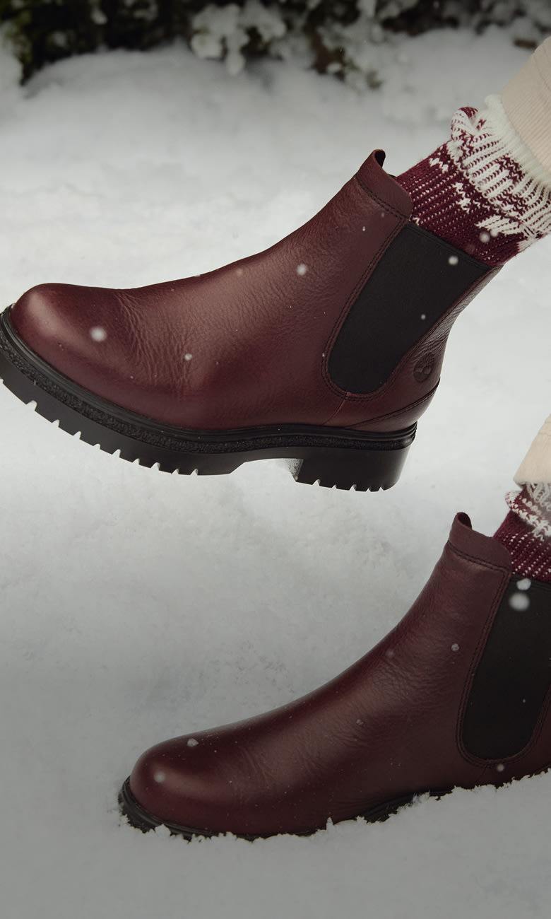 crossed legs with red boots in snow