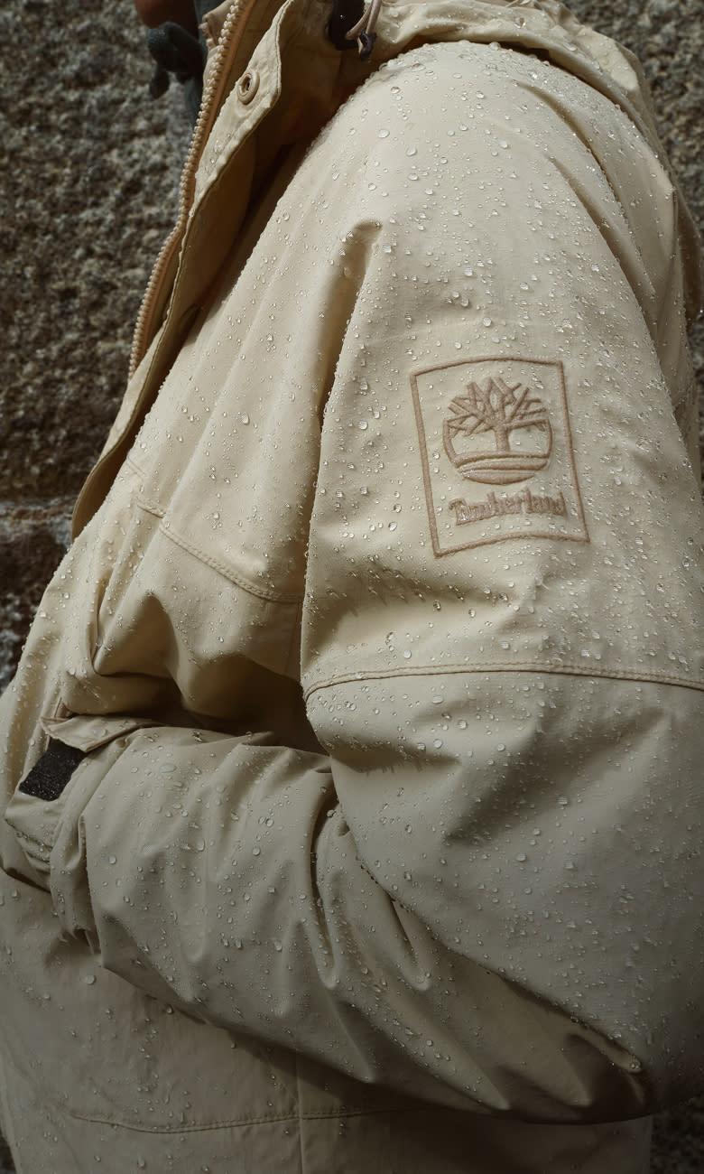 person wearing a tan coat with timberland logo