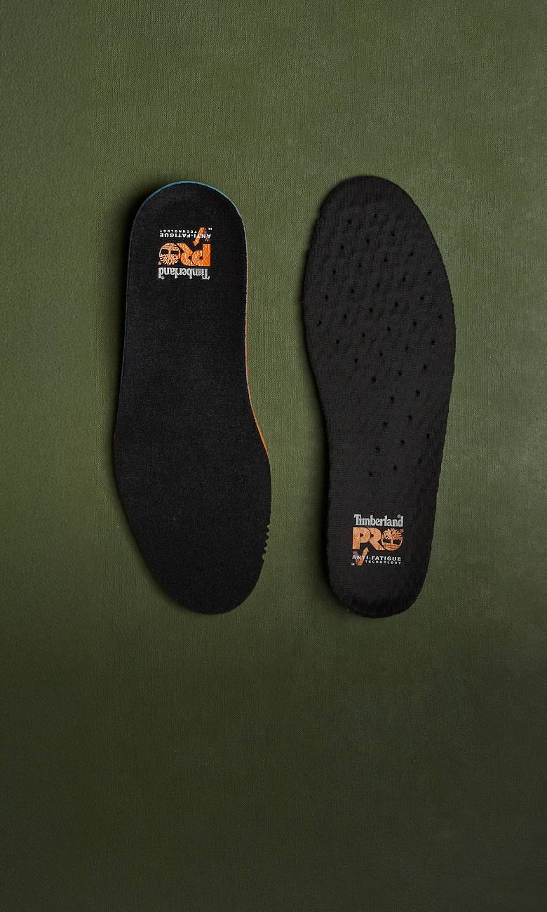 two timberland shoe insoles on a green surface