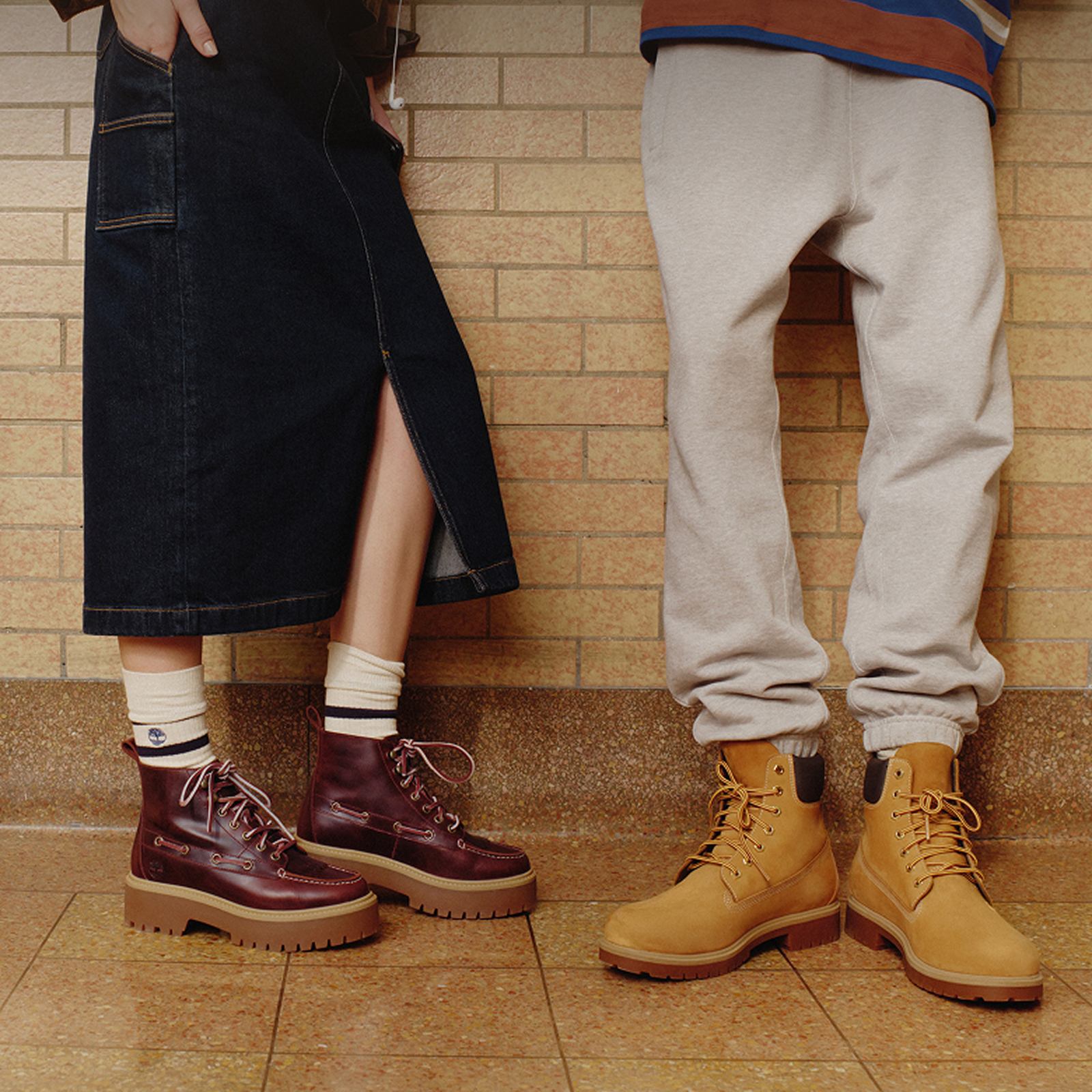 two pair of legs of a woman and man standing next to each other wearing timberland shoes