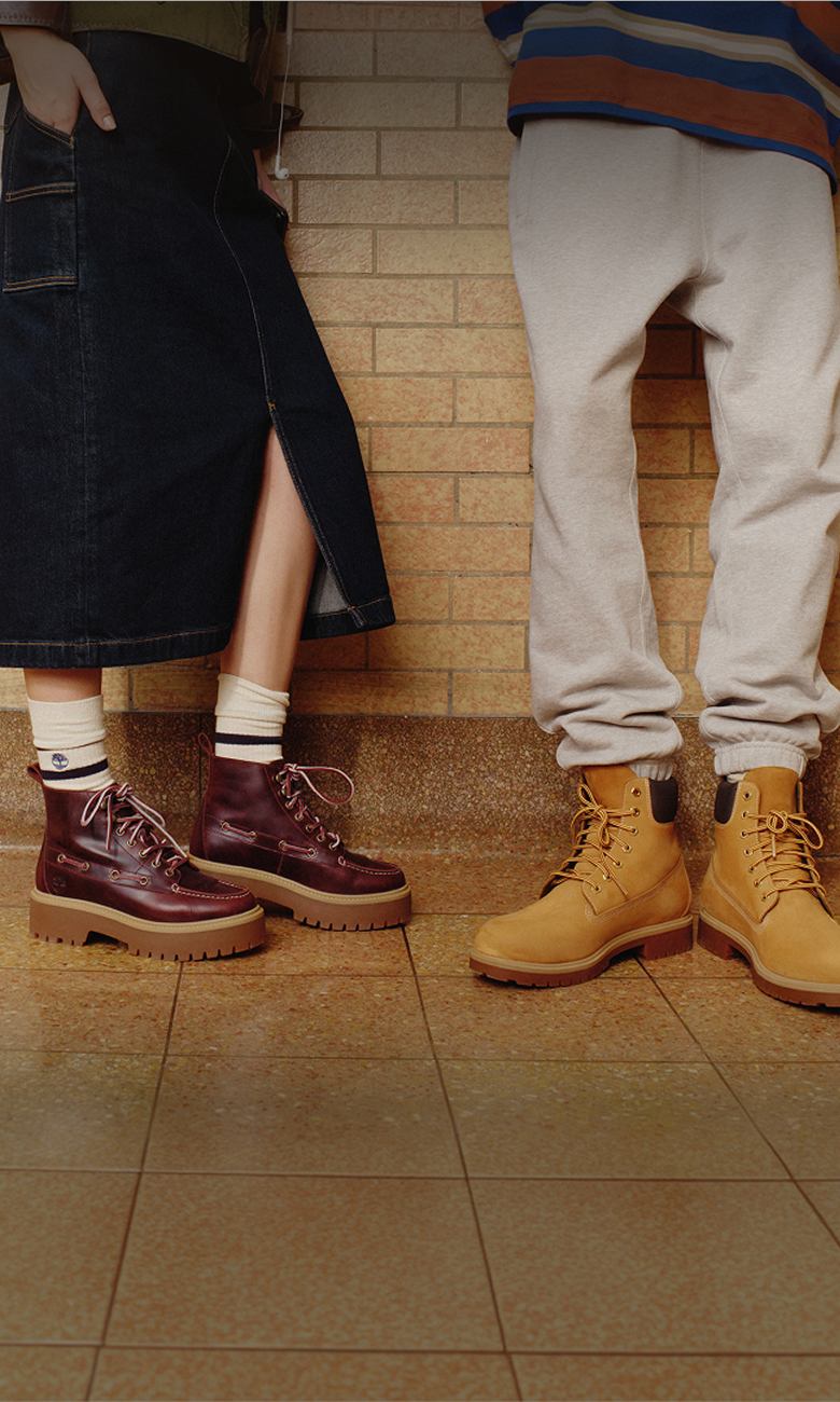 a woman's legs wearing a long skirt and timberland boots 