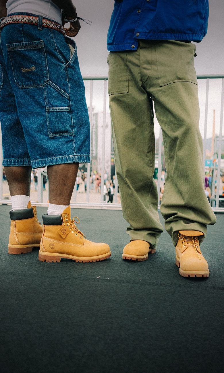 a close up on two sets of feet wearing classic timberland boots in the summer